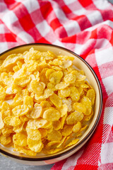 crispy golden cornflakes on a gray concrete background