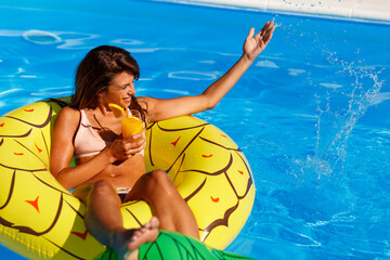 Woman having fun at swimming pool while on summer vacation