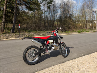 Fototapeta na wymiar A red off-road motorcycle set on an asphalt road