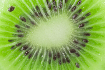 Background image: Juicy pulp of an exotic tropical fruit green kiwi with black seeds