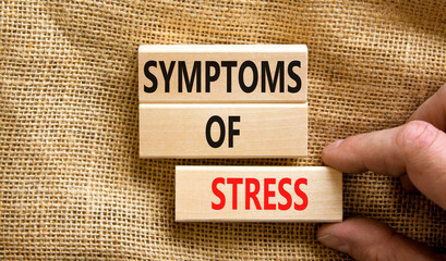 Symptoms of stress symbol. Concept words Symptoms of stress on wooden blocks. Beautiful canvas table canvas background. Doctor hand. Psychological business and Symptoms of stress concept. Copy space.