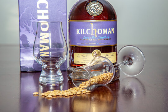 Bras&iacute;lia, DF, Brazil, May 19, 2022: Kilchoman Sanaig single malt Scotch whisky on rustic wooden table with malted and peated sevada seeds. Peated barley