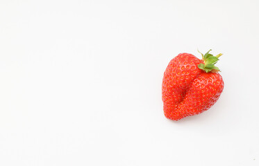 One fresh strawberries in the shape of a heart on a white background.Valentine's Day concept. Flat lay,copy space, top view.