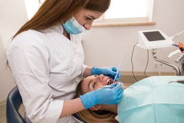 dentist conduct examination and treatment of teeth of the patient