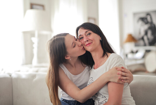 daughter kisses her mother on the cheek