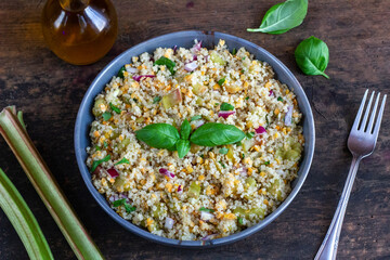 Wiosenna sałatka z rabarbaru i komosy ryżowej posypana zieloną bazylią. Kuchnia wegetariańska, zdrowe jedzenie - obrazy, fototapety, plakaty