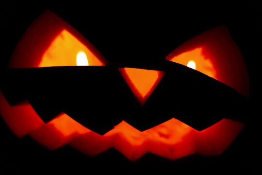 Scary pumpkin face with candles glowing in the night