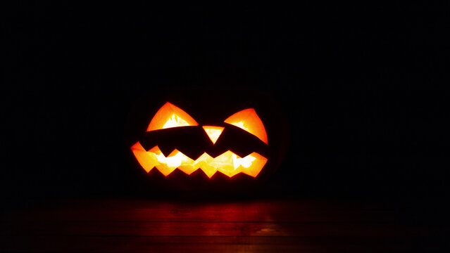 Halloween scary pumpkin glow on black background at night