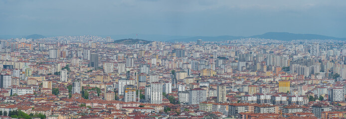 Obraz na płótnie Canvas Panoramic aerial view of densely built-up district in Istanbul city with small mountains in the background