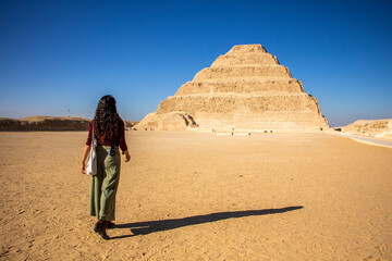 Woman walking towards Pyramid Djoser at Saqqara near Cairo in Egypt