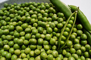 Top view of Fresh Green peas. Organic green vegetables in bowl with multicolor background. Hara matar dana Green pea seeds raw tender. Space to write text font - obrazy, fototapety, plakaty