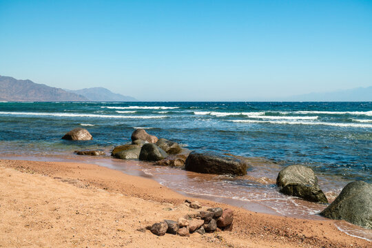 Egypt, Sinai, Wet stones on beach and sea