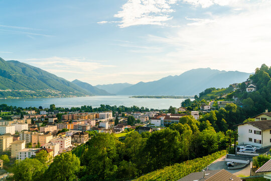 Switzerland, Ticino, City and lake in mountain landscape
