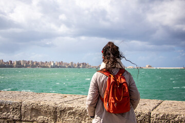 Woman looking at Alexandria city in Egypt, sky with clouds