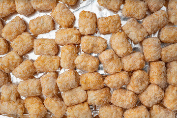 Uncooked Frozen Tater Tots on Aluminum Foil