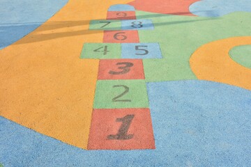 Rayuela de colores hecha en el suelo de un parque infantil
