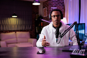 POV of young influencer recording podcast episode on camera, talking into microphone for sound...