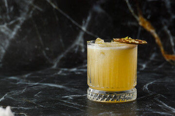 Fruit mixology with mezcal and dry lime on black marble background. Warm colored cocktails. Mezcal...