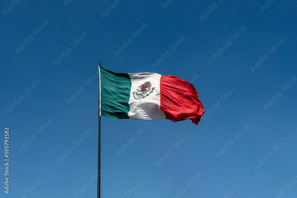 Wall mural mexico national offcial flag on clean and clear blue sky background