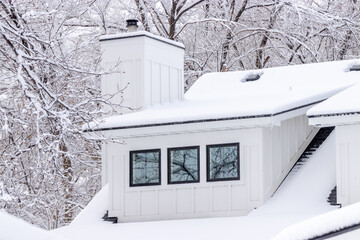 A modern farmhouse covered in a fresh layer of winter snow.
