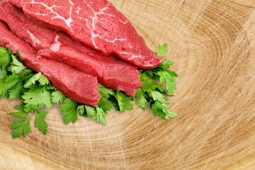 Red Raw beef rib eye steak prepared  with herbs on a dark textured background. Fresh meat