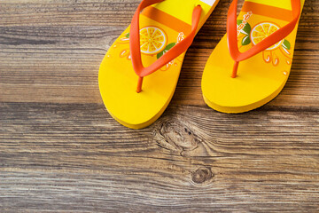 Yellow color flip-flops soft sponge slippers on wooden surface,half view with copy space