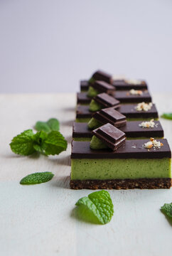 A row of raw chocolate mint slice with mint leaves.