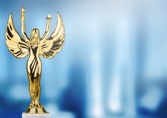 Golden award statue on light rays background. Success and victory concept.