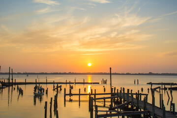 Sunrise on the Indian River at an old marina with wooden piers near Melbourne, Florida close to...