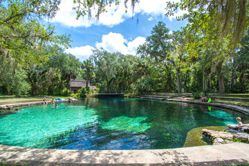A family enjoying a cool dip in a natural fresh water springs swimming hole at Juniper Springs in...