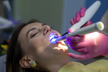 The process of removing braces.Beautiful woman in dental chair during procedure of installing...