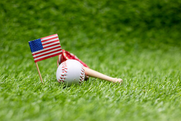 Baseball and ball for 4th July on green grass