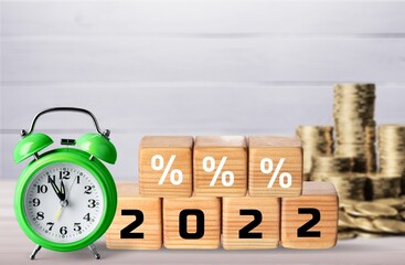Wooden cube block icon 2022 percent with coin and alarm clock.