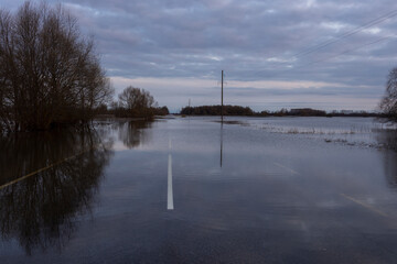 Road flooding. Evening landscape with a flooded river. Spring rural landscape.