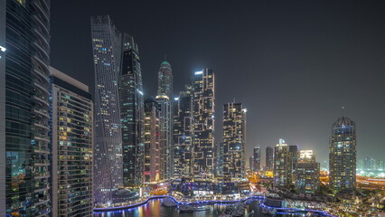 Fototapeta na wymiar Dubai marina tallest skyscrapers and yachts in harbor aerial night timelapse.
