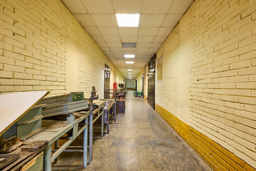 The long beige corridor with brick walls