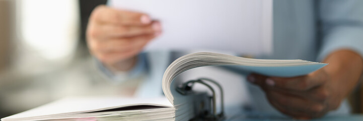 Business woman in suit looking documents from folder closeup