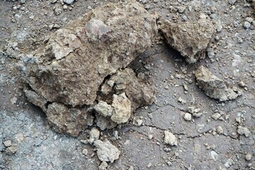 Grau-braune Felsbrocken auf nasser grauer Erdfläche 