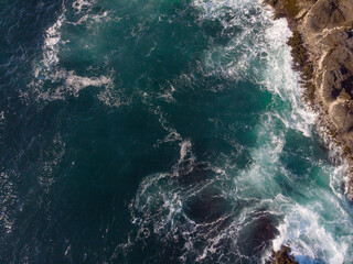 Shooting from a drone. Foamy ocean waves and rocky shore. Abstraction. There are no people in the...
