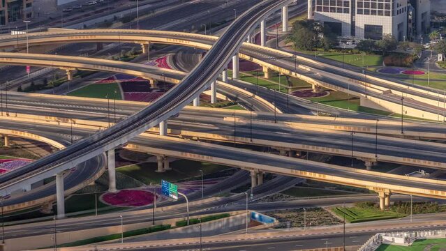 Highway intersection and overpass of Dubai downtown aerial timelapse. Huge road junction with busy traffic from above during sunset.