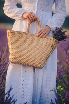 woman in white dress holding bouquet of lavender flowers
