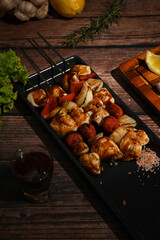 Close up of grilled vegetables and meat on sticks on rustic wooden table. Barbecue, food, party concept