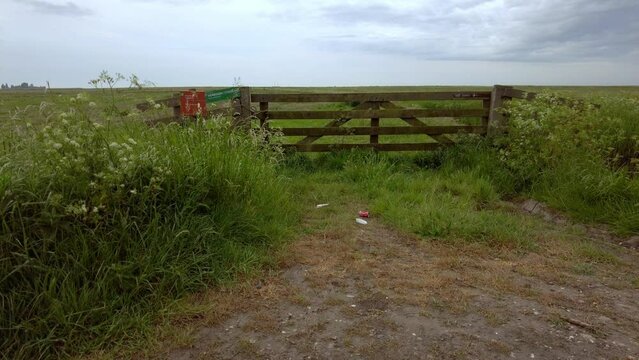 Garbage dumped at the fence of a nature reserve. At the gate are two no-entry signs of the bird nature reserve state forest management, close-up view