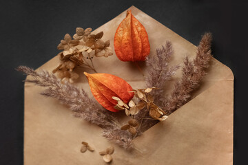 Autumn decorative composition with dried pampas grass and physalis flowers in craft envelope