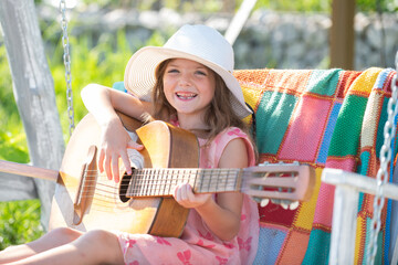 Child musician playing the guitar like a rockstar. Summer activity for children in warm weather....