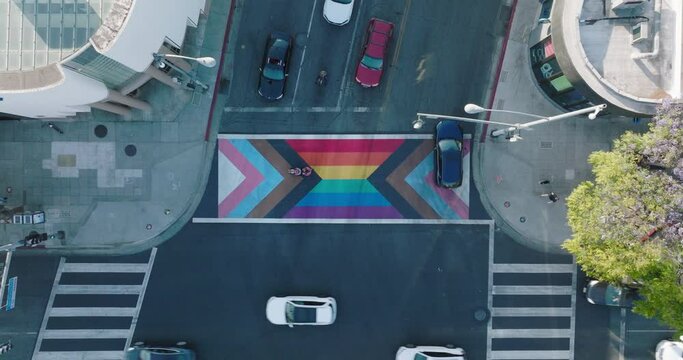 Aerial Footage Over Colorful Rainbow Patterned Intersection, Cars Turning and Pedestrians Walking