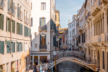 Fototapeta na wymiar Cityscape of the beautiful narrow water channels on a sunny day in Venice. Traveling Italy concept