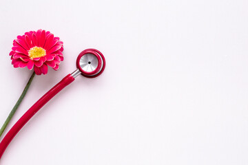 Women health background with red stethoscope and flower