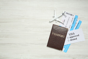 Passport, toy plane and tickets on white wooden background, flat lay with space for text. Visa receiving