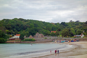 Fototapeta na wymiar Panorama of the sweeping and beautiful St Brelade’s bay in Jersey in the Channel Islands U.K. with the pretty St Brelade’s church in the background 
